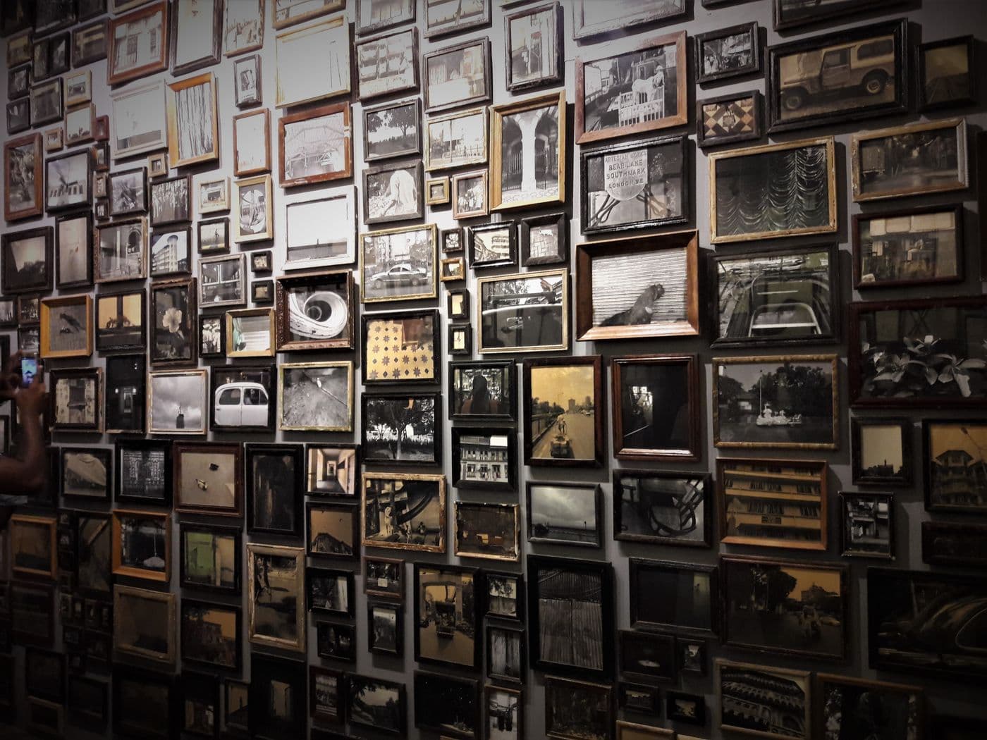 A wall arranged with a collage of framed photographs